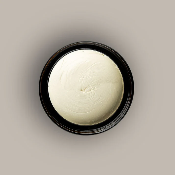 Cream-coloured balm in the open jar — top-down view